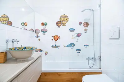 a bathroom with a tub and a shower with drawings of balloons at Lion 99 in Rome