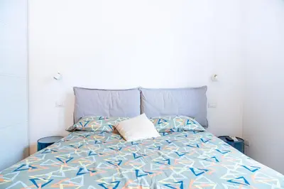 a bed with a blue comforter and two pillows at Lion 99 in Rome
