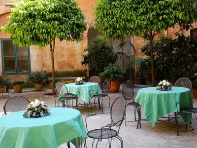 two tables and chairs with green table cloths at Casa Di Santa Francesca Romana a Ponte Rotto in Rome