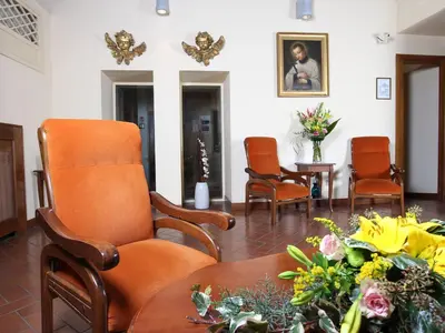 a waiting room with chairs and a table and flowers at Casa Di Santa Francesca Romana a Ponte Rotto in Rome