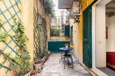 a small patio with a table and chairs in a building at Delizioso appartamento a Trastevere in Rome