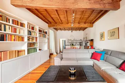 a living room with a couch and bookshelves at Delizioso appartamento a Trastevere in Rome