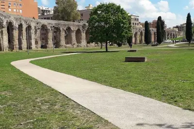 a path in a park with a building in the background at La finestra sul Nasone in Rome