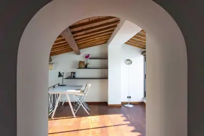 an archway leads into a dining room with a table at Lusso e panorama senza paragoni, Loft Trastevere in Rome