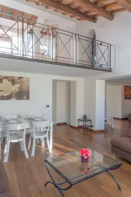 a living room with a glass table and a loft at Lusso e panorama senza paragoni, Loft Trastevere in Rome