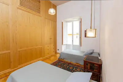 a bedroom with two beds and a window at Habitat's Navona 4BR Apartment in Rome