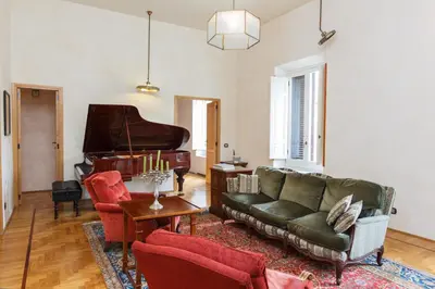 a living room with a couch and a piano at Habitat's Navona 4BR Apartment in Rome