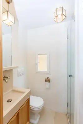 a bathroom with a toilet and a sink and a mirror at Habitat's Navona 4BR Apartment in Rome