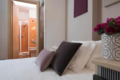 a bedroom with a white bed with two pillows on it at 111 ColaDiRienzo Rooms - by AD Roma in Rome