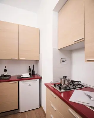 a kitchen with a stove and a white refrigerator at 111 ColaDiRienzo Rooms - by AD Roma in Rome