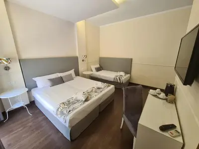a small room with two beds and a television at Caesar Place in Rome