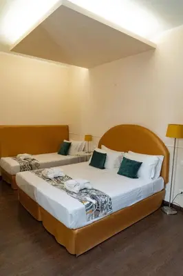two beds in a hotel room with a large at Caesar Place in Rome