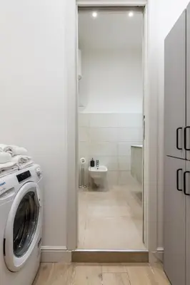 a bathroom with a washing machine and a toilet at Homs Boutique Apartment in Rome