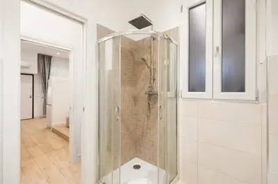 a shower with a glass door in a bathroom at Homs Boutique Apartment in Rome