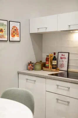 a kitchen with white cabinets and a counter top with spices at Homs Boutique Apartment in Rome