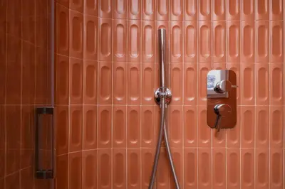 a brick wall with a shower in a bathroom at Prati Zen Boutique Studio-ZEN37 in Rome