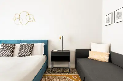 a living room with a couch and a bed at Donatello Boutique Apartment in Rome