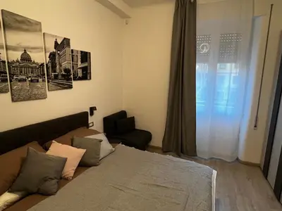 a bedroom with a bed and a chair and a window at Love4Rome Guest House in Rome