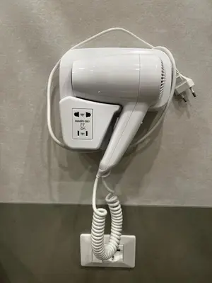 a white hairdryer hanging on a wall at Love4Rome Guest House in Rome