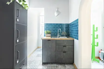 a kitchen with a sink and blue tiles at Trastevere 68 Stylish Apartment in Rome
