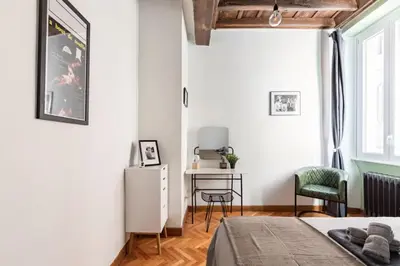 a bedroom with a bed and a desk with a chair at Trastevere 68 Stylish Apartment in Rome
