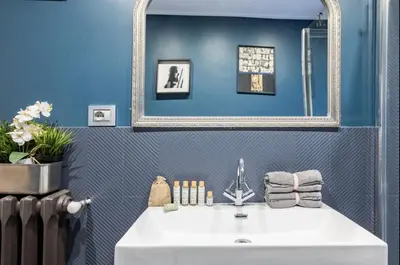 a bathroom with a white sink and a mirror at Trastevere 68 Stylish Apartment in Rome