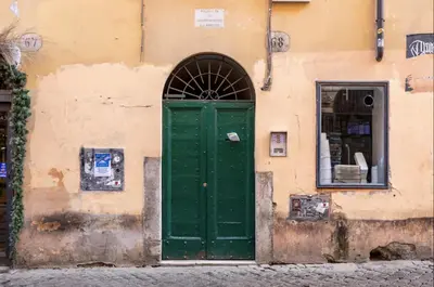 a green door on the side of a building at Trastevere 68 Stylish Apartment in Rome