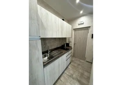 a kitchen with white cabinets and a sink at La Palmetta - Vicino Metro A in Rome