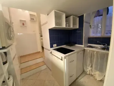 a small kitchen with white cabinets and a sink at NAVONA DOMITIA HOME in Rome
