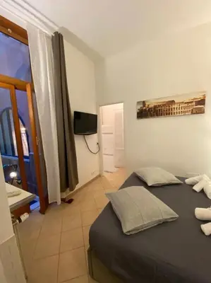a bedroom with a bed and a tv and a window at NAVONA DOMITIA HOME in Rome