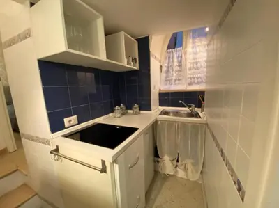 a small kitchen with white cabinets and a sink at NAVONA DOMITIA HOME in Rome
