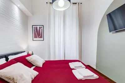 a bedroom with a red bed with two white pillows at BDC - Fancy 2-Bdr Apt @Vatican in Rome