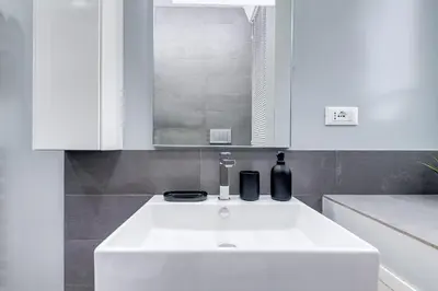 a bathroom with a white sink and a mirror at BDC - Fancy 2-Bdr Apt @Vatican in Rome