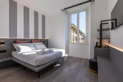 a bedroom with a large white bed and a window at Veneto Suite Roma in Rome