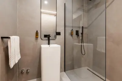 a bathroom with a shower and a toilet and a glass door at Veneto Suite Roma in Rome