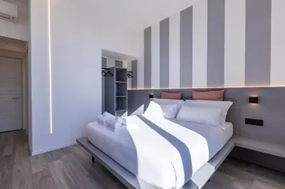 a bedroom with a large white bed with white pillows at Veneto Suite Roma in Rome