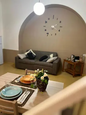 a living room with a couch and a clock on the wall at Sapri Apartment - Castro Pretorio by GHOR in Rome