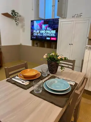 a dining room table with plates and a tv at Sapri Apartment - Castro Pretorio by GHOR in Rome