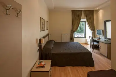 a hotel room with a bed and a desk and a window at My Rooms in Rome