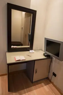 a desk with a television and a mirror at My Rooms in Rome