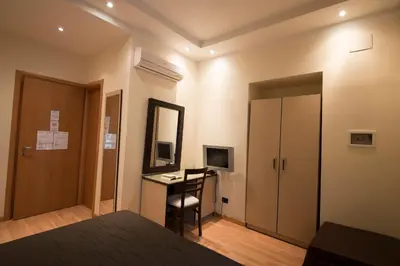 a hotel room with a desk and a bed and a mirror at My Rooms in Rome