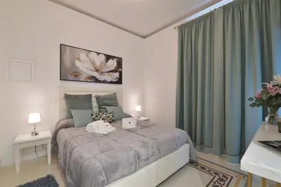 a bedroom with a large bed with green curtains at Trinita Rooms in Rome