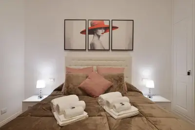 a bedroom with a bed with a woman in a hat at Trinita Rooms in Rome