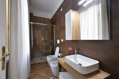 a bathroom with a white sink and a toilet at Trinita Rooms in Rome