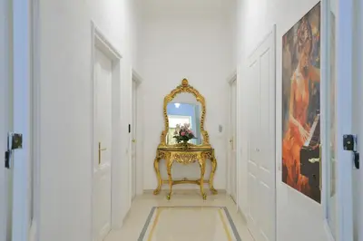 a hallway with a mirror and a gold console at Trinita Rooms in Rome