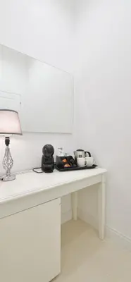 a white table with a lamp and bowls on it at Trinita Rooms in Rome