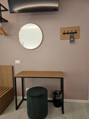 a mirror on a wall with a table and a green stool at Massimi City Garden in Rome