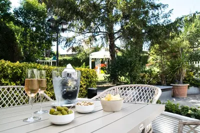 a table with wine glasses and bowls of food on it at Massimi City Garden in Rome