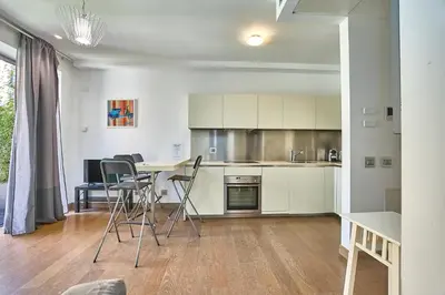 a kitchen with white cabinets and a table and chairs at Hella Urbana 152 in Rome