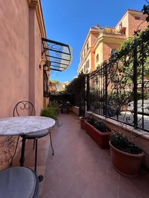 a patio with a table and chairs and a building at èROMA - AVENTINO Apartment in Rome